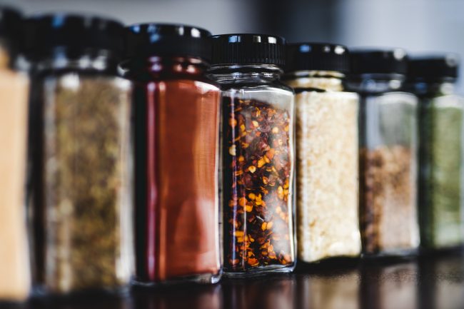 spices seeds and seasonings in matching spice jars on tidy pantry shelf
