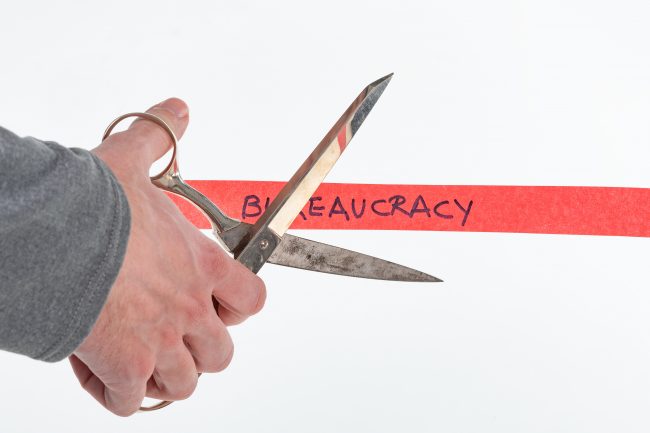 cutting red tape labeled bureaucracy