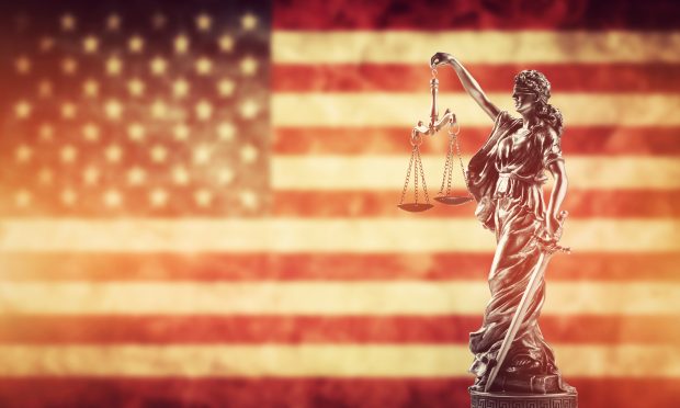 Law concept. Themis statue against USA flag. Symbol of justice, court, trial.