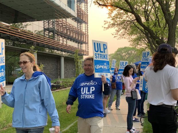 Union employees picket in front of CUNA Mutual Group in Madison, Wis., May 19, 2023.