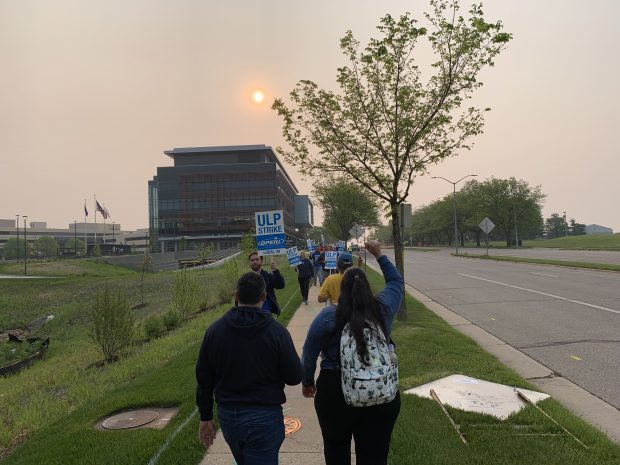 Union employees of TruStage walk the picket lines in front of the company's headquarters in Madison, Wis. on May, 19, 2023 (Source: CU Times).