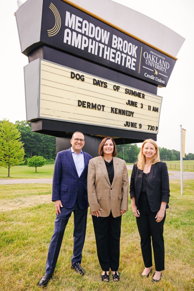 313 Presents President Howard Handler, OU Credit Union President/CEO April Clobes, and OU Credit Union Chief Community Impact Officer Susi Elkins by the new sign displaying OU Credit Union as the exclusive Proud Partner of the Meadow Brook Amphitheatre (Credit: Andrew Potter).