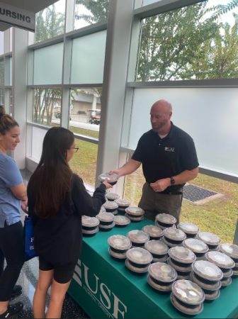 Fredricks distributes healthy meals provided by USF FCU to nursing students at a resource fair with the University of South Florida's College of Nursing.