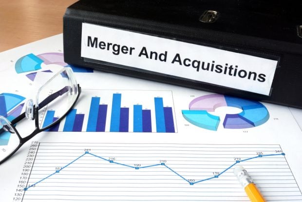 binder on a desk titled merger and acquisitions
