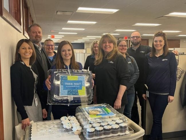 Draheim (far left) and Fox Communities Chief Lending Officer Adam Landsverk (second from left) deliver cupcakes to their credit card and loan processing team members