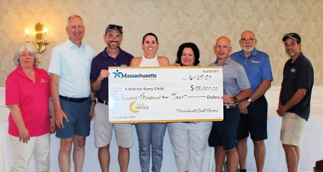 Members of the Massachusetts Credit Unions Social Responsibility Committee, along with CCUA President/CEO Ronald McLean (second from left), present a $100,000 check to Tina Baptista (fourth from left), program director for A Bed for Every Child