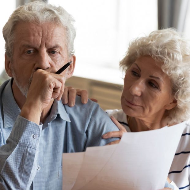Two older people looking concerned about finances as they look at their account balances