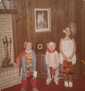 4-year-old Michael as a clown, highlighted by wood paneling.