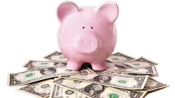 Pink piggy bank on money (Image: Shutterstock)